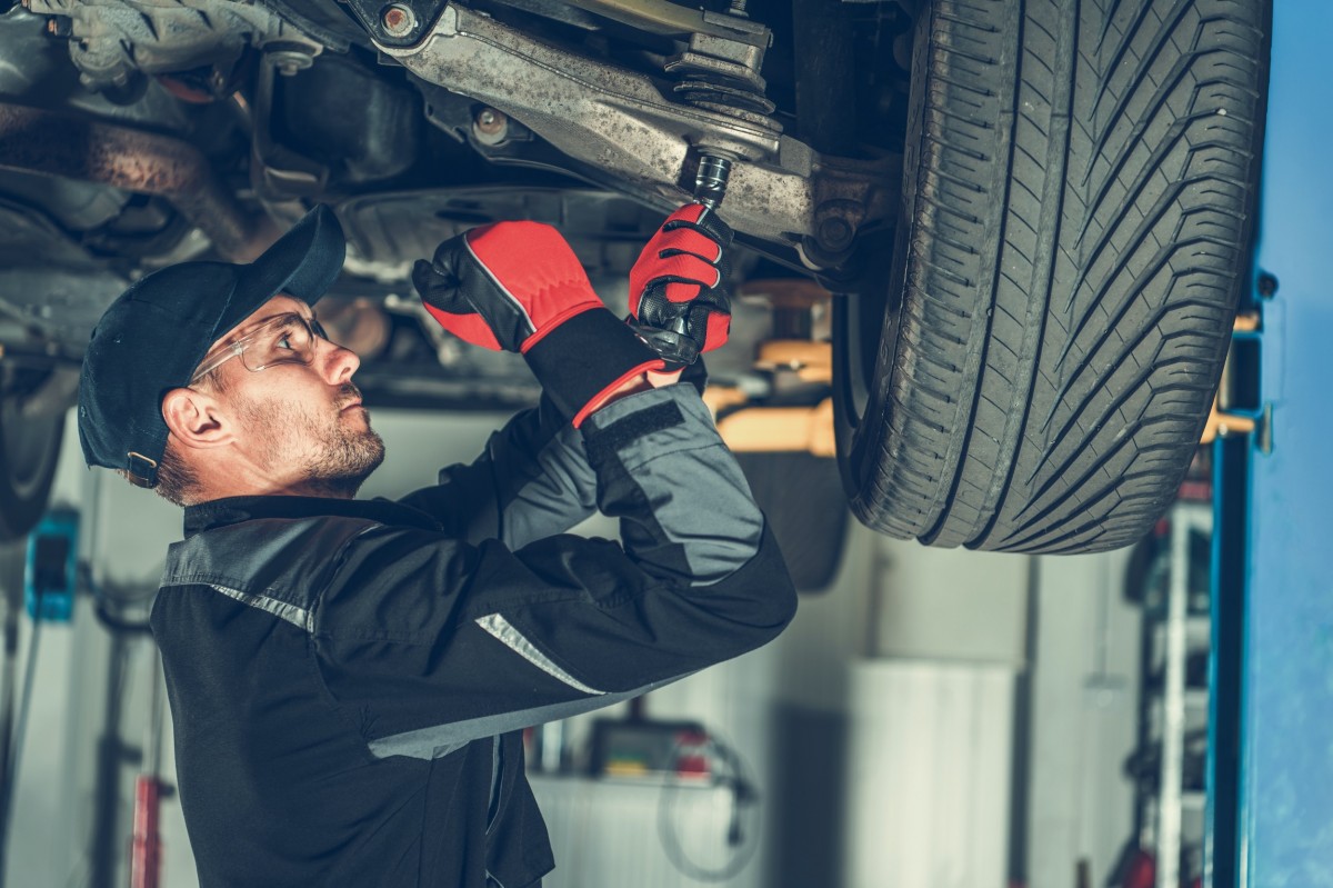 mechanic working on ball joints on a vehicle