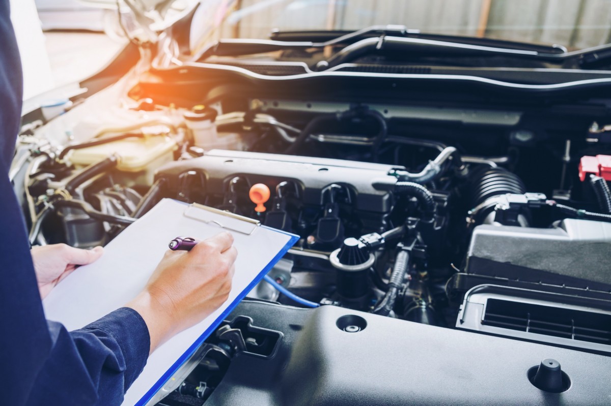 mechanic with clipboard and pen checking things off